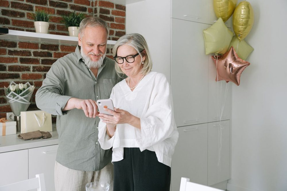 Senior couple looking at a smartphone together at home